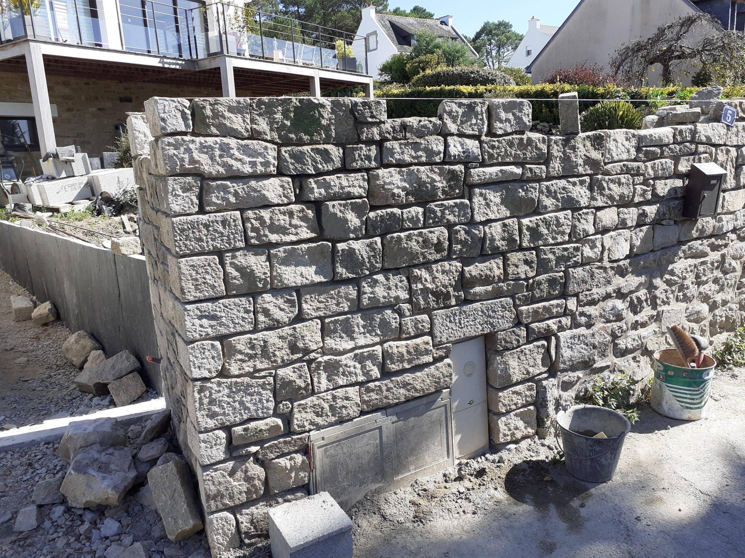 Mur en pierre de granit en cours de construction dans une propriété du littoral morbihannais