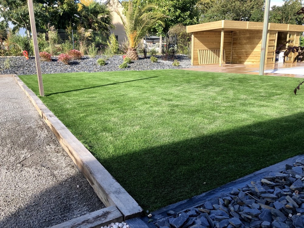 Pelouse synthétique verte entretenue dans un jardin du Morbihan